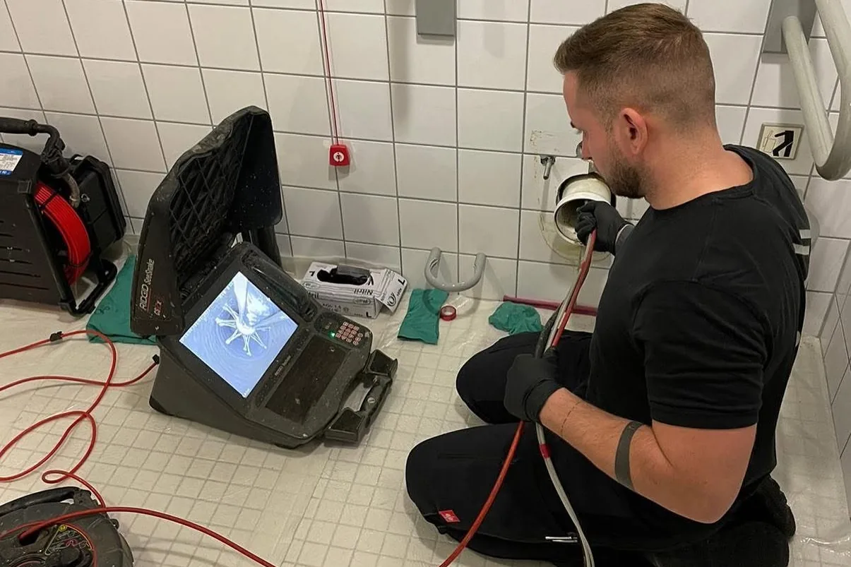 Kamera der Kanal-TV-Untersuchung wird im Sanitärraum in eine Abwasserleitung eingeführt, Einsatz von P&N