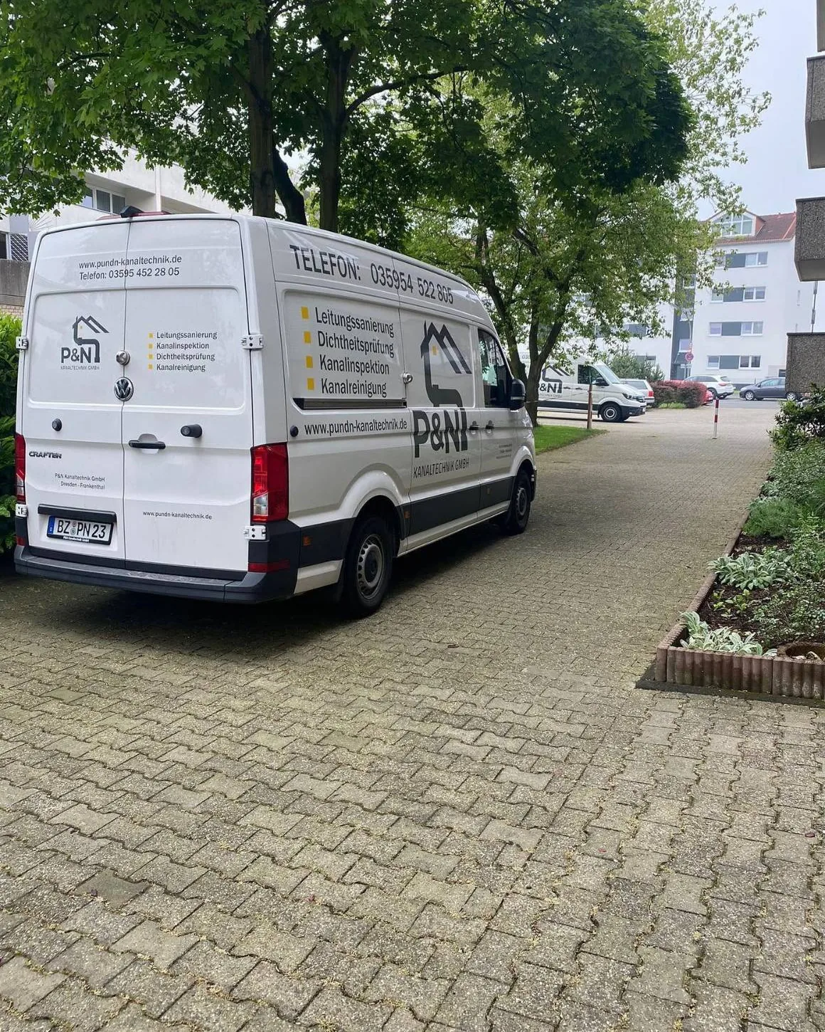 Einsatzfahrzeug des Partnerbetriebs P&N zwischen Wohngebäuden